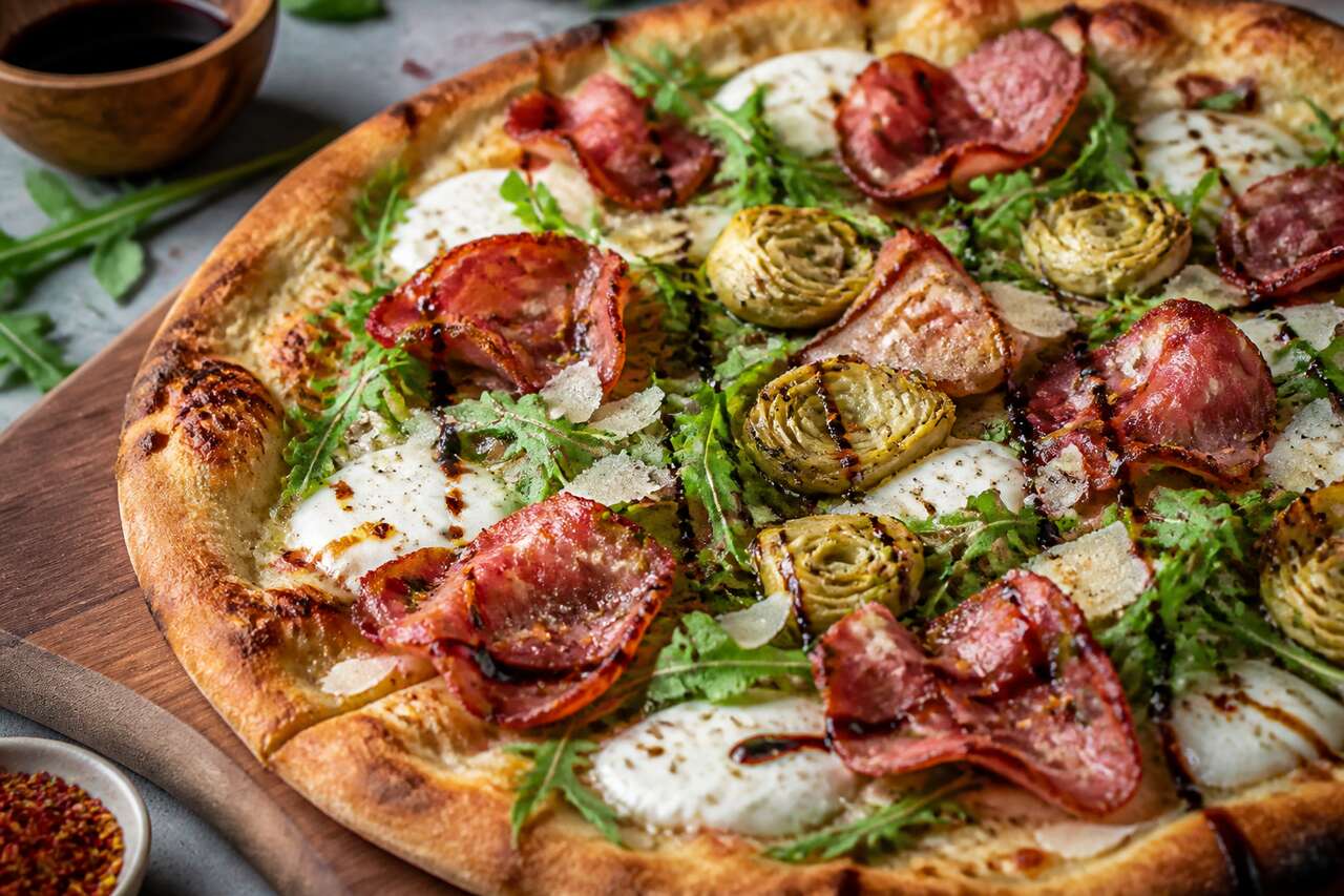 Pizza gourmande d'été aux artichauts grillés, pancetta et roquette